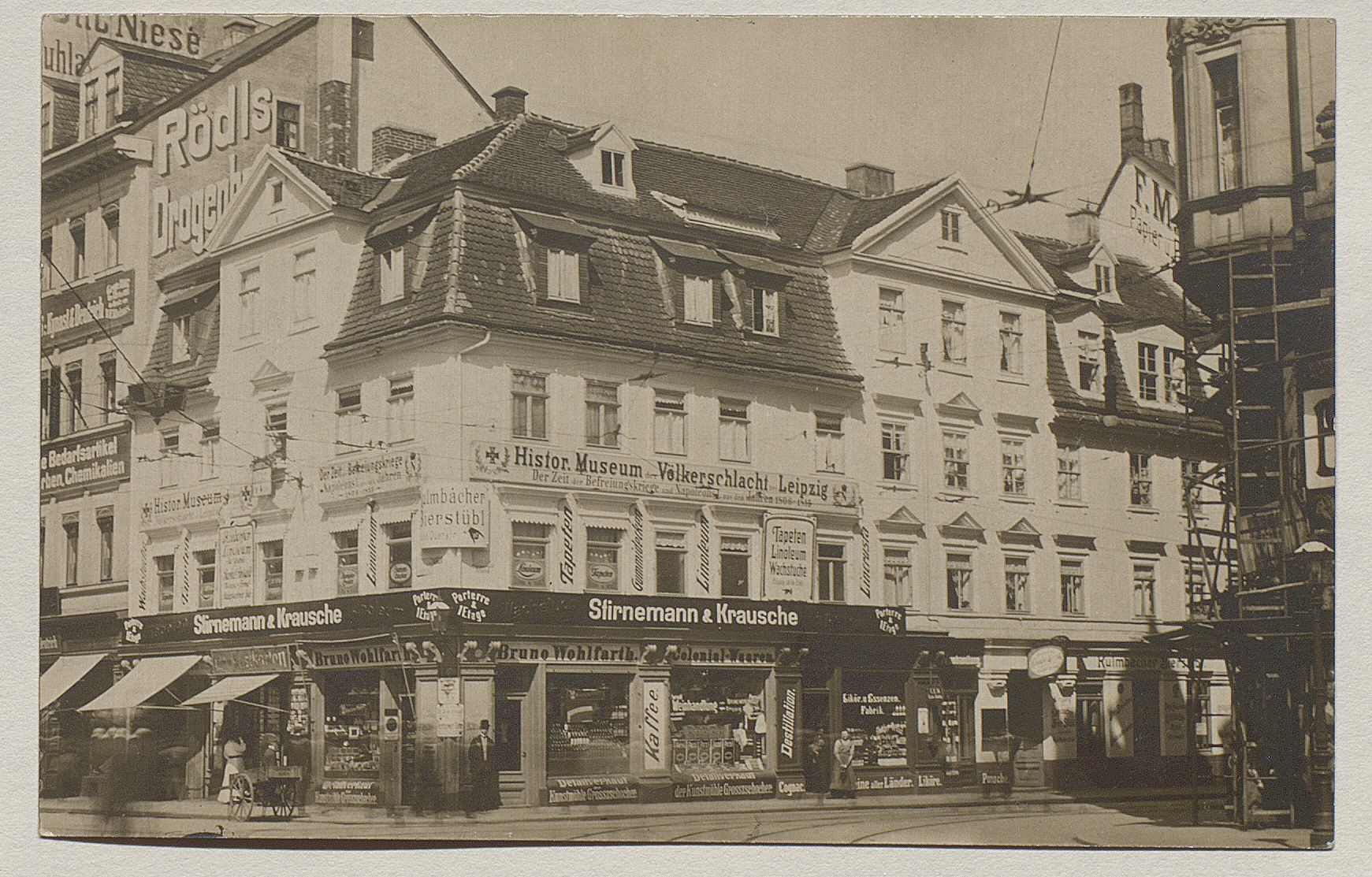 Fotografie des Völkerschlachtmuseums, ein dreistöckiges Eckgebäude mit Geschäften im Erdgeschoss